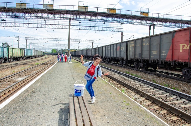 Uma garota em uma plataforma do país perto do trem.