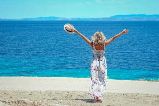 Uma garota feliz perto da beira-mar em viagens de fim de semana na natureza