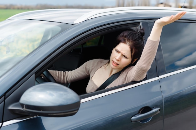 Uma garota furiosa agarra o volante com força, frustração evidente em seus olhos Presa no trânsito lento, ela anseia por se libertar e escapar do incessante rastejar de carros