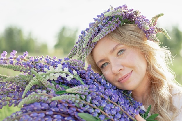 Foto uma garota hippie segurando um buquê de flores silvestres em suas mãos garota escondeu o rosto atrás de um buquê de tremoços