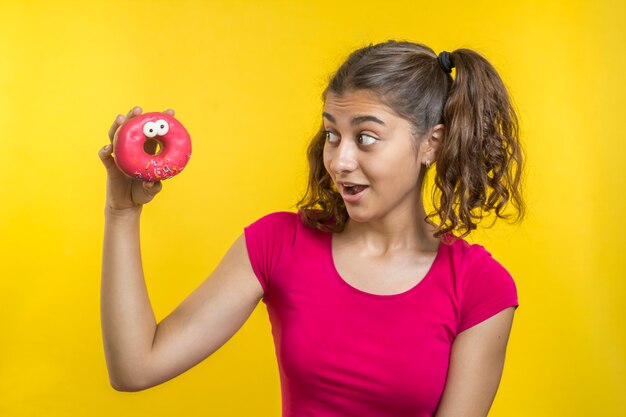 Uma garota indiana está olhando para um donut