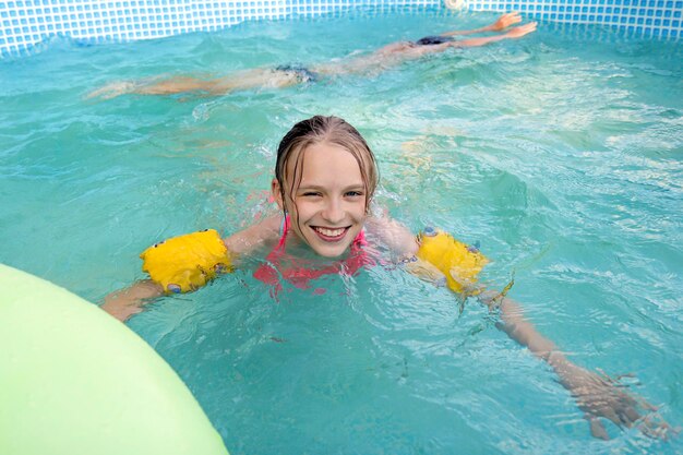 Uma garota nadando alegremente na piscina no verão