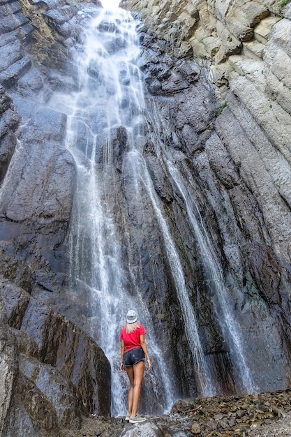 Uma garota no fundo da cachoeira AbaiSu North Caucasus KabardinoBalkaria Junho de 2021