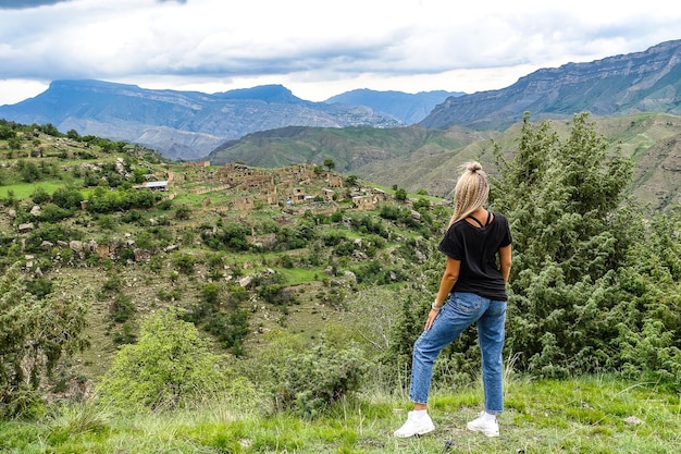 Uma garota no fundo da vila de Kurib nas montanhas do Cáucaso no topo de um penhasco Daguestão Rússia junho de 2021