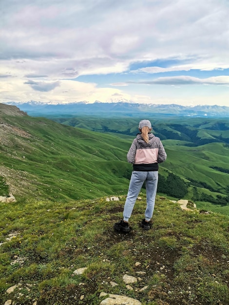 Uma garota no fundo das montanhas e do planalto de Bermamyt na Rússia junho de 2021