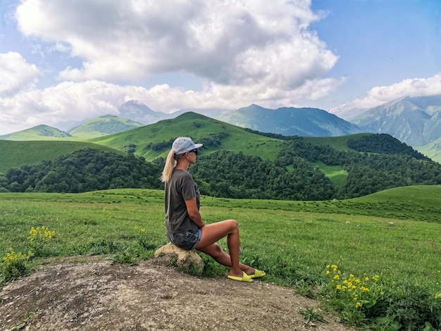 Uma garota no fundo de uma paisagem verde da passagem de Aktoprak no Cáucaso Rússia junho de 2021