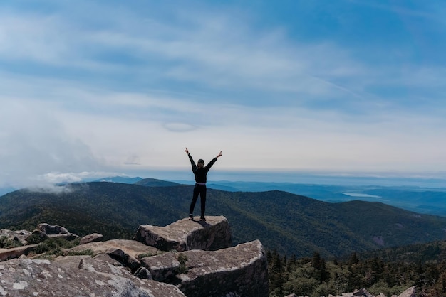 Uma garota no topo do Monte Pidan olha para um belo vale montanhoso no nevoeiro no verão Viagens e turismo Caminhadas