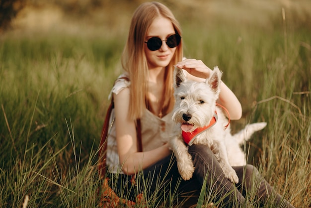 Uma garota segura um cachorro terrier nos braços