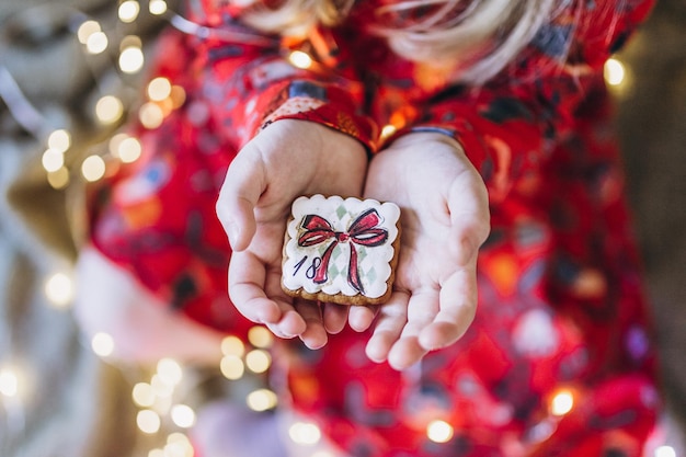 Uma garota segura um pão de mel de Natal nas mãos. Backgraund boche