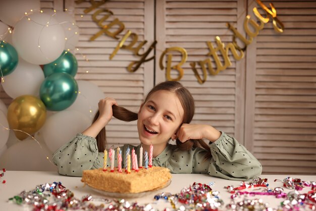 Uma garota soprando velas em um bolo de aniversário