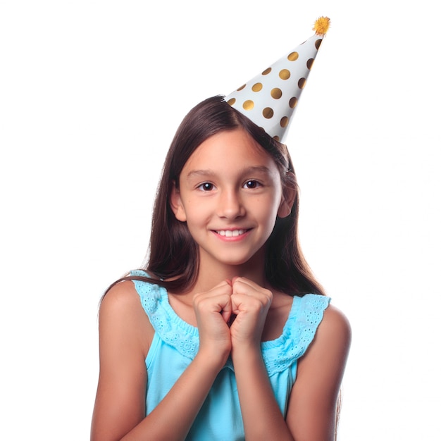 Uma garota sorridente feliz em um chapéu festivo, esperando por uma celebração de férias