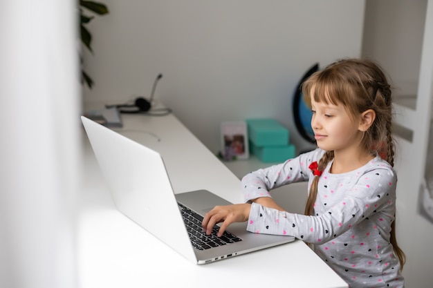 Uma garota videoconferência com uma professora feliz no laptop