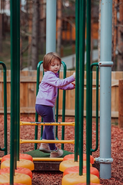 Uma garotinha brincando no parque. O conceito de convívio familiar no parque. Uma garota balança em um balanço, joga jogos criativos.