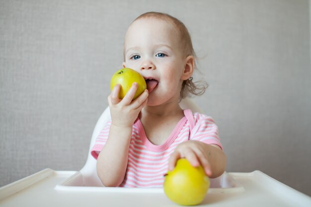 Uma garotinha comendo maçãs frescas