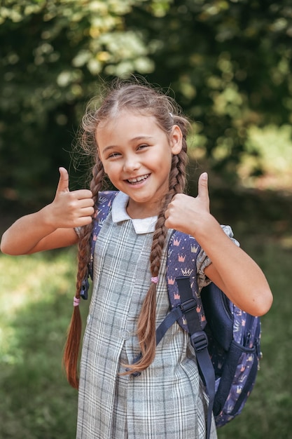 Feliz Bebê Loira Com Duas Pequenas Tranças Em Camiseta Branca E Um Kit De  Calças Jeans Sentado Sobre O Fundo Da Grama Verde Foto de Stock - Imagem de  pouco, inocência: 143643548