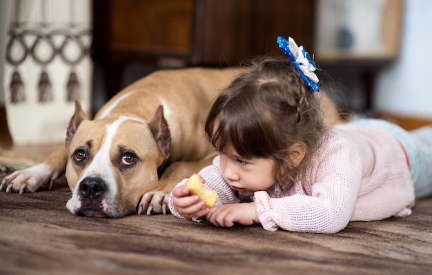 Uma garotinha e um cachorro no apartamento.