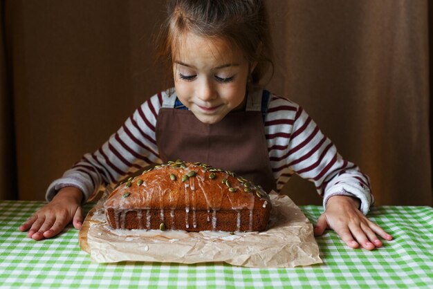 Uma garotinha olha para um delicioso cupcake de dar água na boca