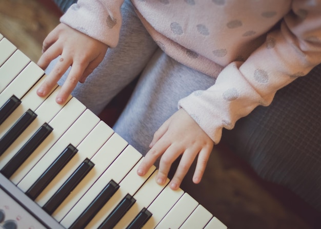 Uma garotinha toca piano elétrico