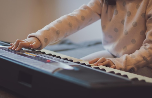 Uma garotinha toca piano elétrico