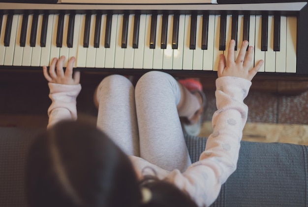 Uma garotinha toca piano elétrico