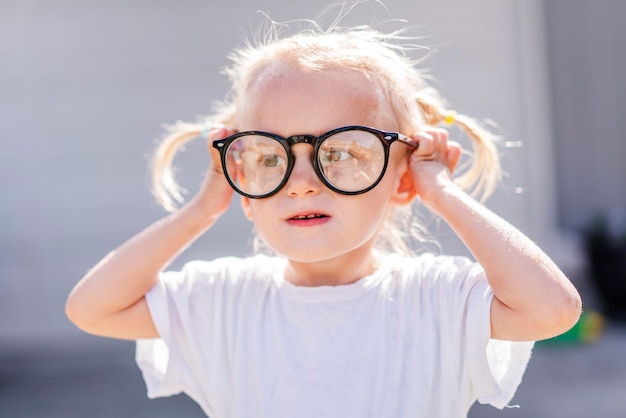 Foto uma garotinha usando óculos que dizem 'eu sou um nerd'