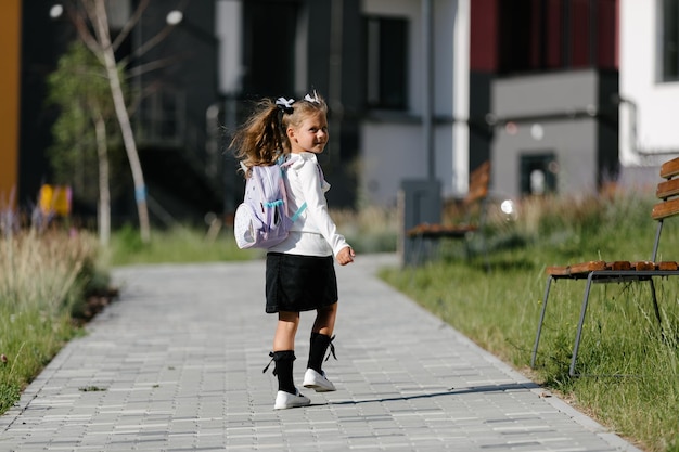 uma garotinha vai para a escola pelo parque ao longo do caminho. conceito de educação a distância. estudante
