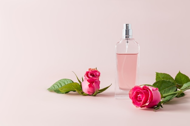 Uma garrafa chique de perfume feminino e um delicado chá de flor de rosa com um botão de rosa Vista frontal Garrafa sem nome para introdução do produto