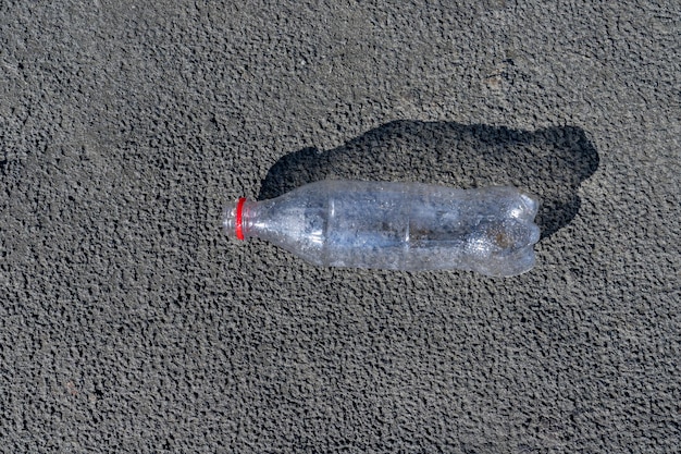 Uma garrafa de plástico na margem de um rio