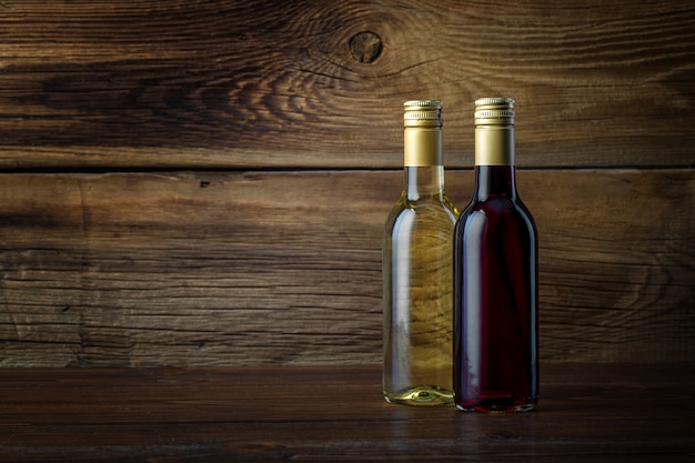 Uma garrafa de vinho tinto e branco em um fundo de madeira