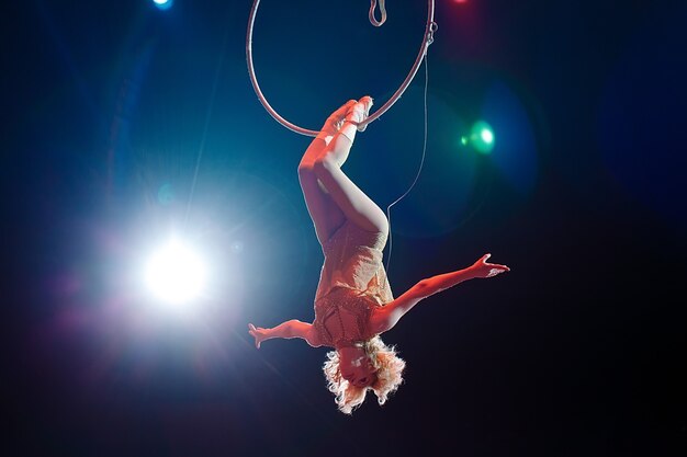 Foto uma ginasta aérea mostra uma performance na arena do circo.