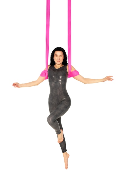 Uma ginasta faz um exercício em um pano rosa no ar em uma superfície branca