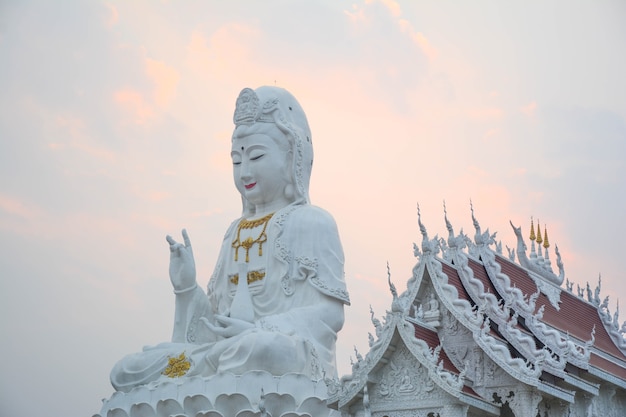 Uma grande e bela estátua antiga de Guan Yin é combinada com um belo templo ou oposto