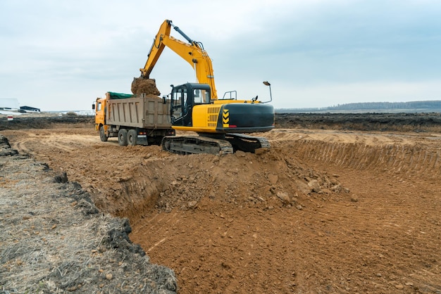 Uma grande escavadeira de cor amarela no canteiro de obras em uma pedreira para pedreiras