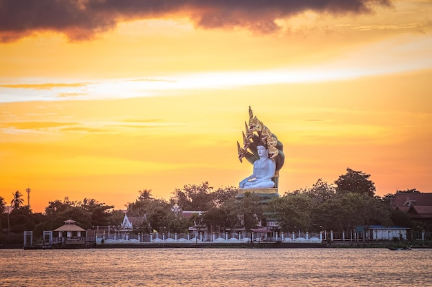 Uma grande estátua do autor fica em um lago em frente ao pôr do sol.