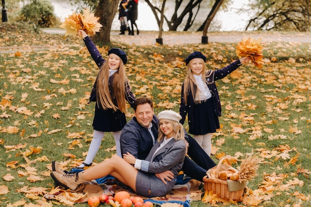 Uma grande família em um piquenique no outono em um parque natural Pessoas felizes no parque de outono