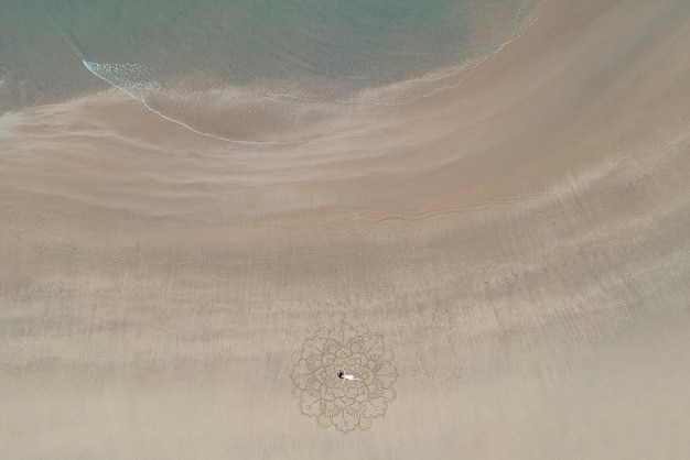 Uma grande mandala pintada na areia na costa do oceano