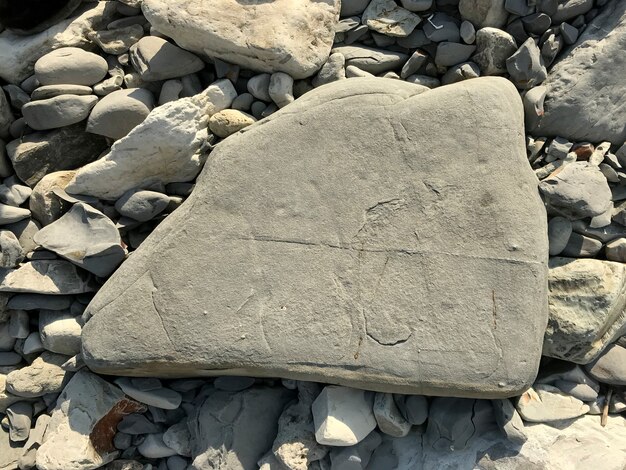 Uma grande pedra repousa sobre um seixo do mar na praia. pedaço de rocha. Foto de alta qualidade