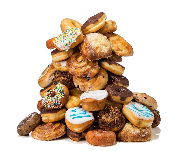 Foto uma grande variedade de bolinhos de rosquinhas e bolos em uma grande pilha em um fundo branco