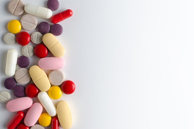 Uma grande variedade de pílulas medicinais em fundo branco
