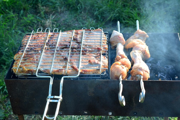 uma grelha com carne de porco e frango isolada com fumaça