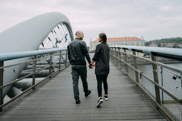 Uma história de amor. Um homem e uma mulher perto da ponte. Relacionamento amoroso. Pôr do sol de outono.