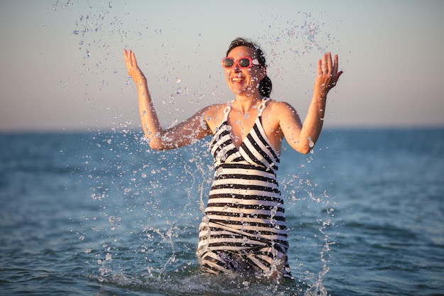 Uma idosa feliz no mar Splash água do mar nas férias