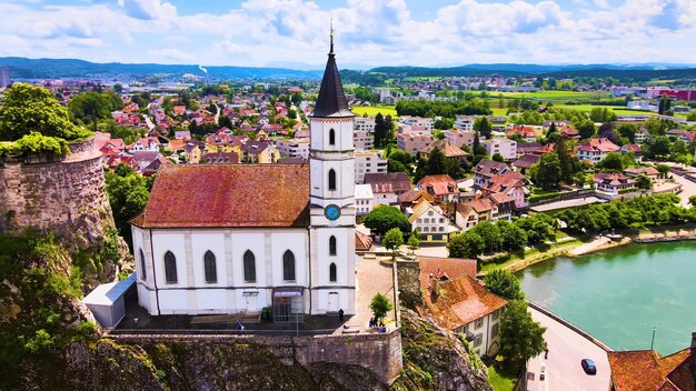 Foto uma igreja em uma colina com um rio ao fundo