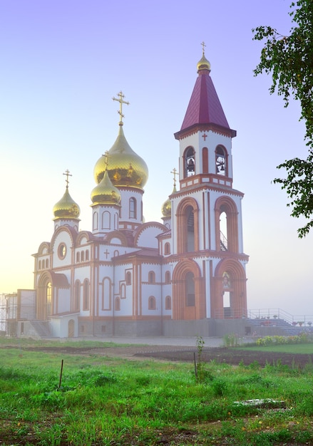Uma igreja ortodoxa em construção no nevoeiro matinal Krasnoyarsk Sibéria Rússia