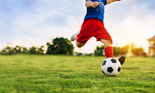 Criança A Jogar Futebol. Um Rapaz Asiático A Dar Pontapés No Ssoccer  Vermelho. Foto Royalty Free, Gravuras, Imagens e Banco de fotografias.  Image 199633197