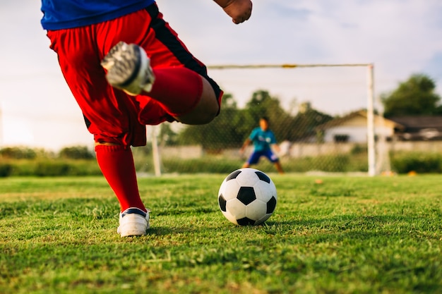 Foto uma imagem de esporte de ação do garoto jogando futebol para o exercício em comunidade sob o