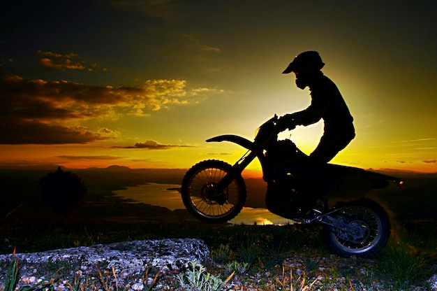 Uma imagem de um motociclista fazendo uma manobra e pulando no ar.