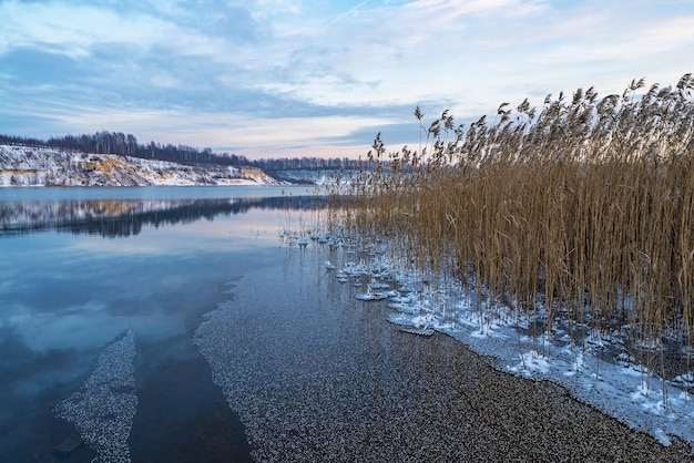 Uma imagem espelhada do céu e da costa com uma cobertura de neve no reservatório