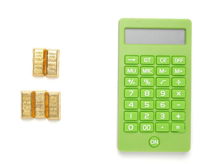 Foto uma imagem plana de miniatura de barra de ouro com calculadora em fundo branco investir e negociar no conceito de ouro