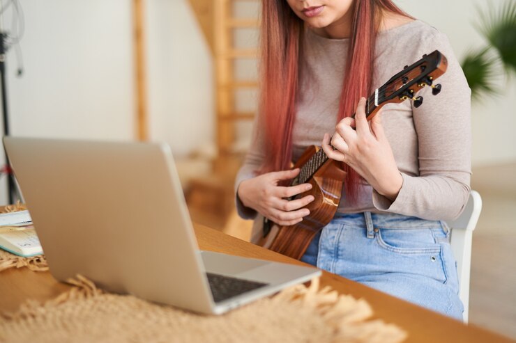 Foto uma imagem sem rosto de uma mulher dando uma aula de ukulele. treinamento remoto de música.